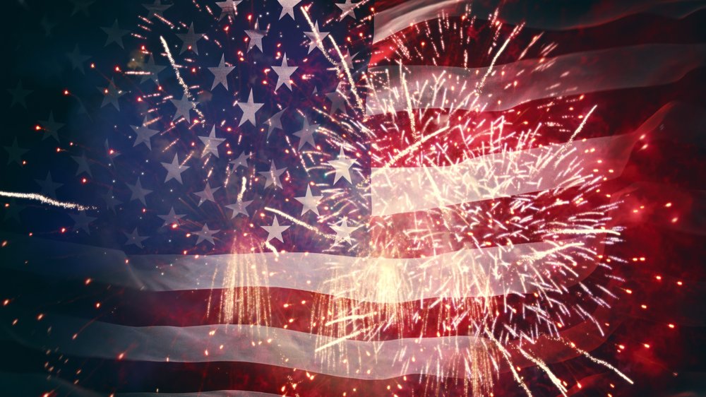 Fireworks display against a semi-transparent American flag background.